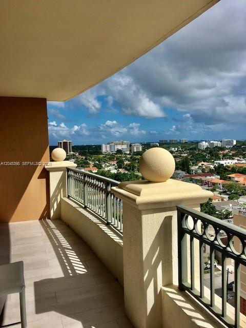 A balcony with a metal railing and spherical stone finials overlooks a suburban cityscape — 3232 SW 22nd Ter # 1303, Miami FL 33145, MIAMI, FL