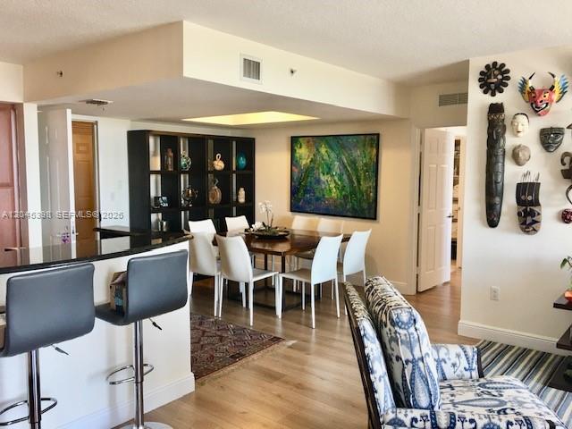 A dining area with a wooden table and chairs sits adjacent to a kitchen counter — 3232 SW 22nd Ter # 1303, Miami FL 33145, MIAMI, FL