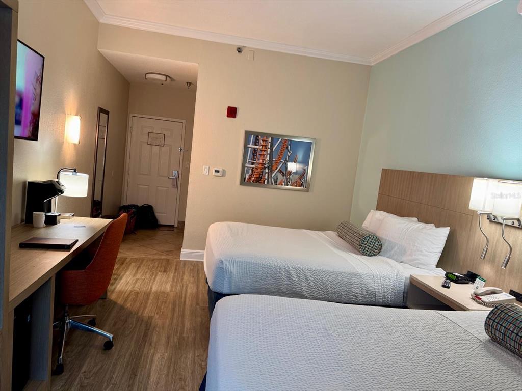 A hotel room features two beds, a desk, and a wall-mounted television — 3000 MAINGATE LN UNIT 319, KISSIMMEE, FL