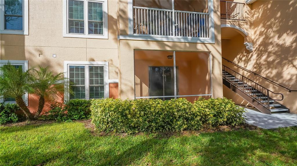 A ground-floor apartment patio with a screen enclosure and an adjacent outdoor staircase — 4160 CENTRAL SARASOTA PARKWAY UNIT 614, SARASOTA, FL
