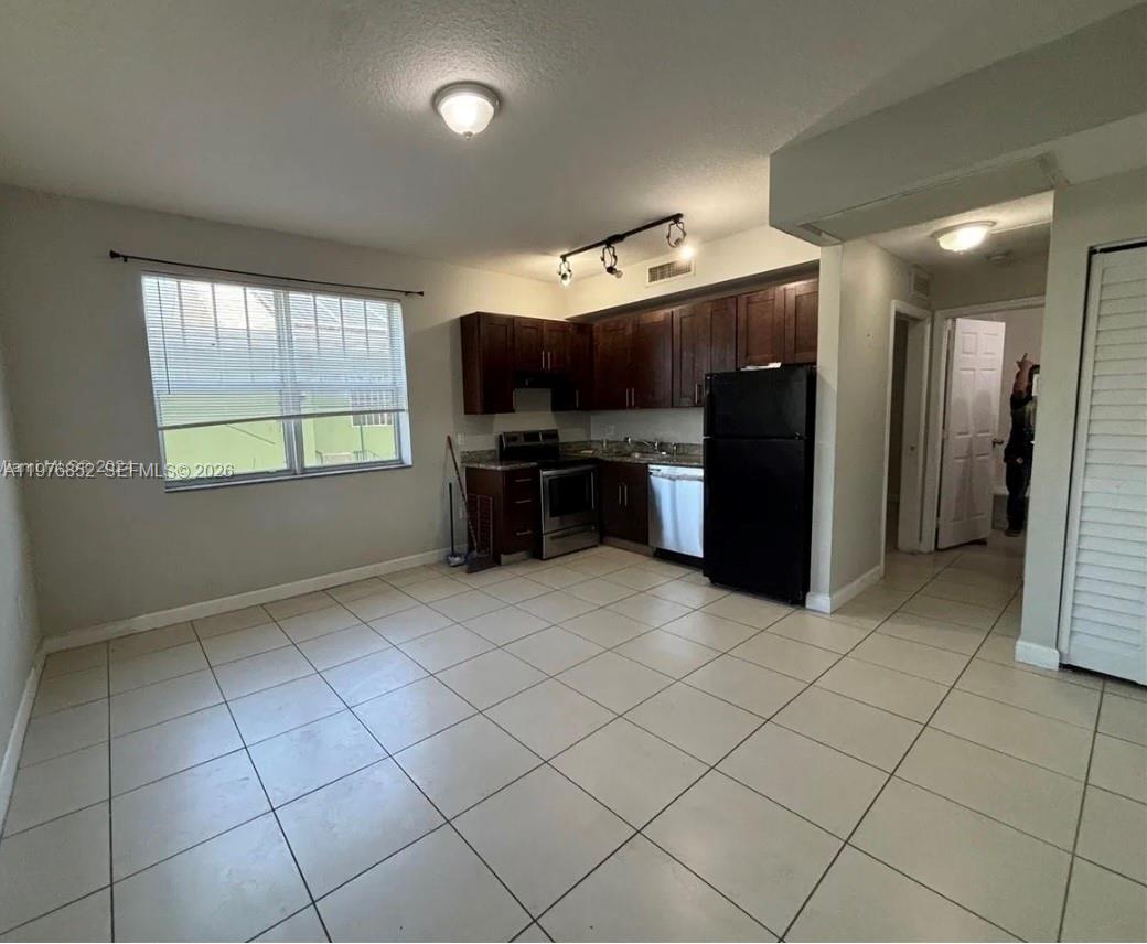 A kitchen with dark wood cabinets, black appliances, and light tile flooring — 843 SW 13th AV # 201, Miami FL 33135, MIAMI, FL