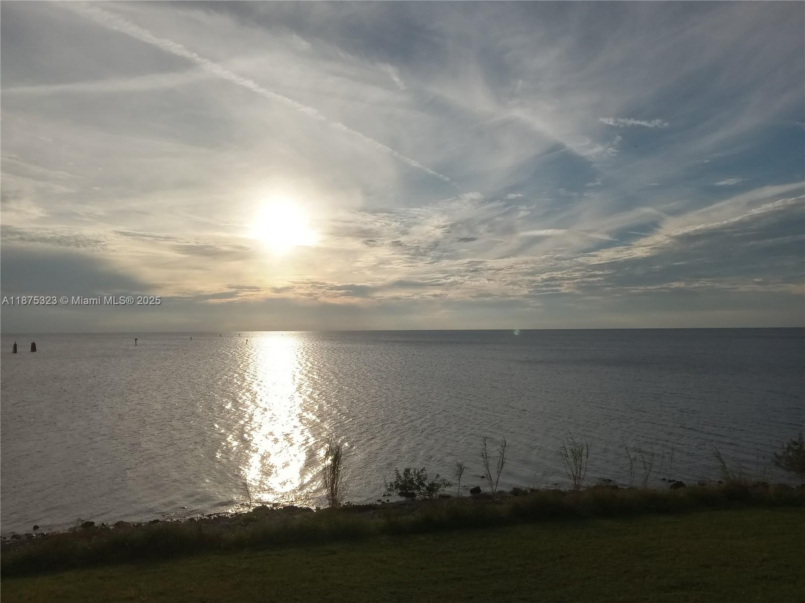 A view of a calm body of water at sunset with a grassy shoreline — 15800 SW Conners Hwy, Okeechobee FL 34974, OKEECHOBEE, FL