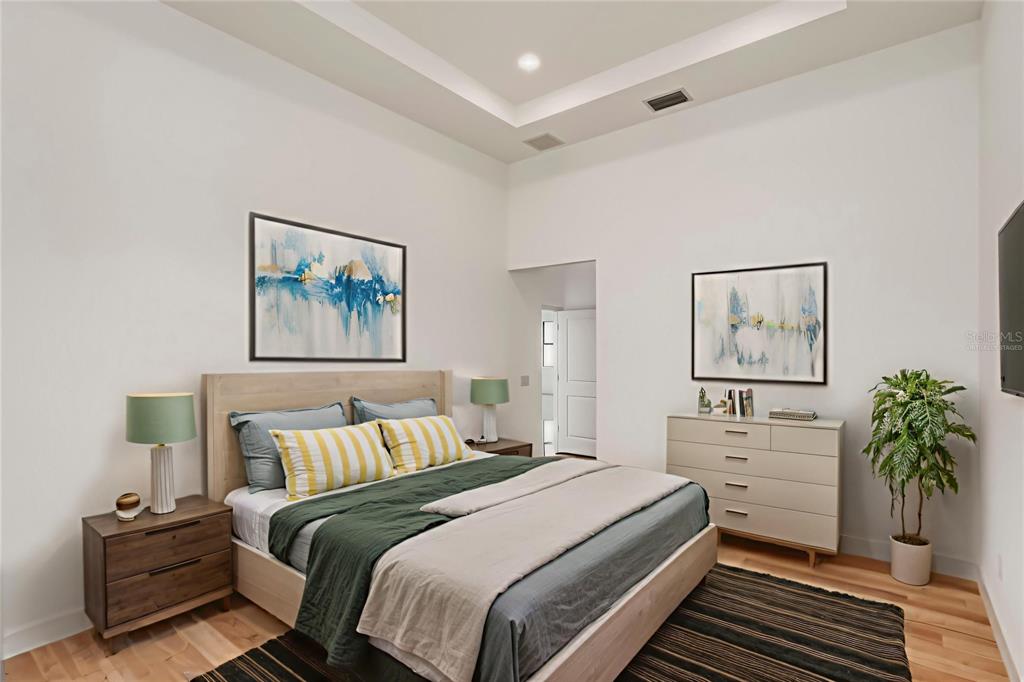 A bedroom features a tray ceiling, a platform bed, two nightstands, and a dresser — 10165 & 10157 KINGSVILLE DRIVE, PORT CHARLOTTE, FL