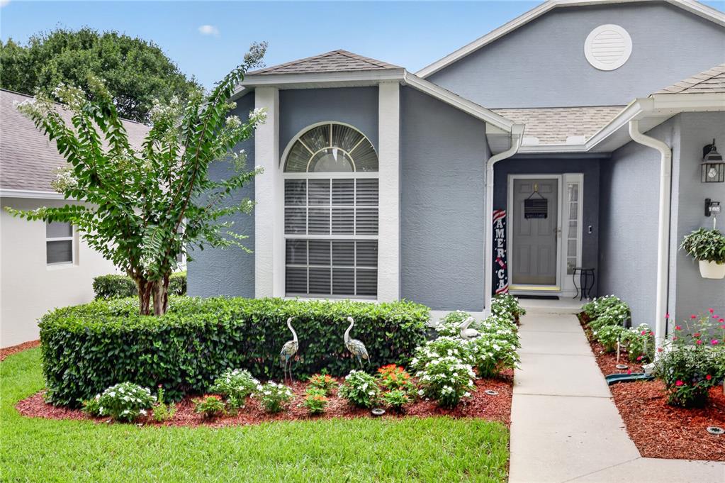 A golf course green features a sand bunker, a golfer, and a parked golf cart — 4059 CAPLAND AVENUE, CLERMONT, FL