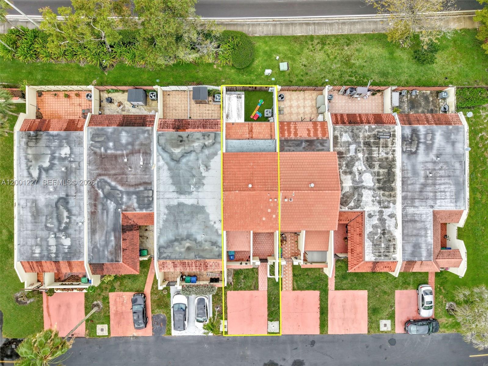 The exterior of a beige stucco house features a red tiled roof and gated entrance — 19252 NW 65th Ct, Hialeah FL 33015, HIALEAH, FL