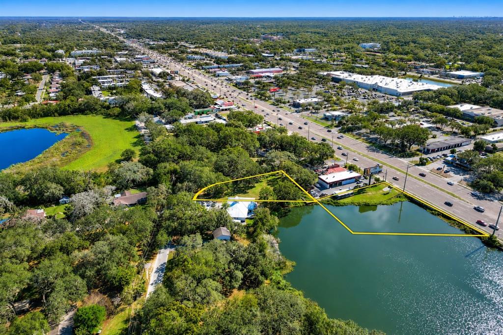 An aerial view shows a waterfront property outlined in yellow next to a busy road — 1214 W BRANDON BOULEVARD, BRANDON, FL