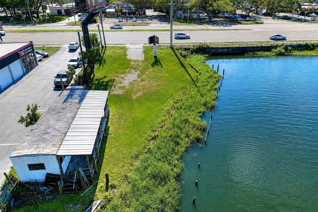 An aerial view shows a small building, a grassy lot, and a waterfront area — 1214 W BRANDON BOULEVARD, BRANDON, FL