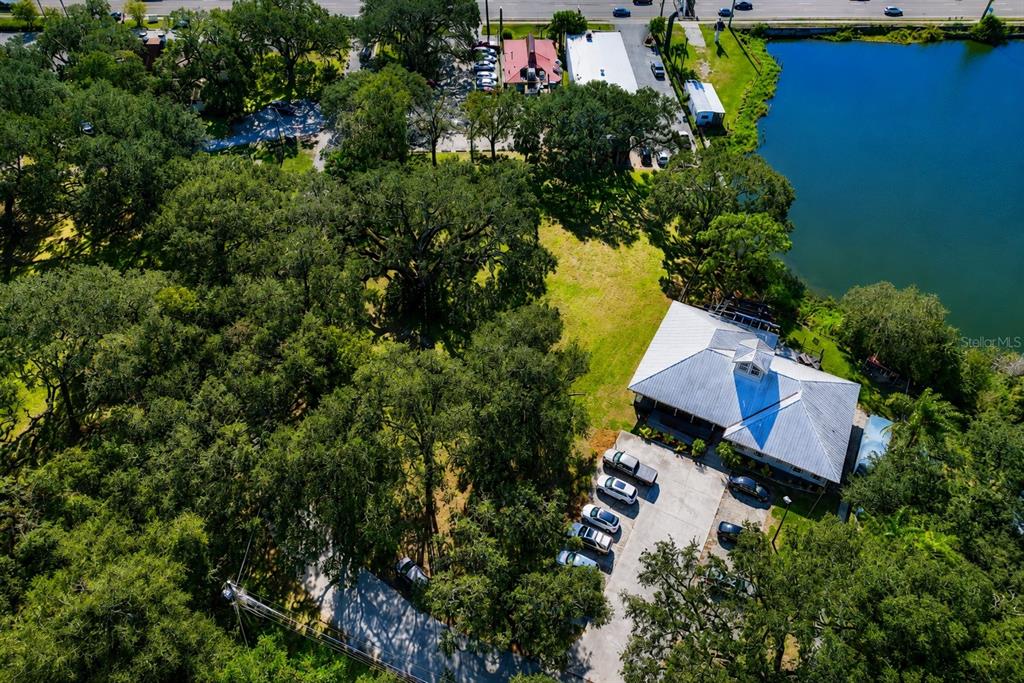 An aerial view shows a building with a metal roof next to a lake — 1214 W BRANDON BOULEVARD, BRANDON, FL