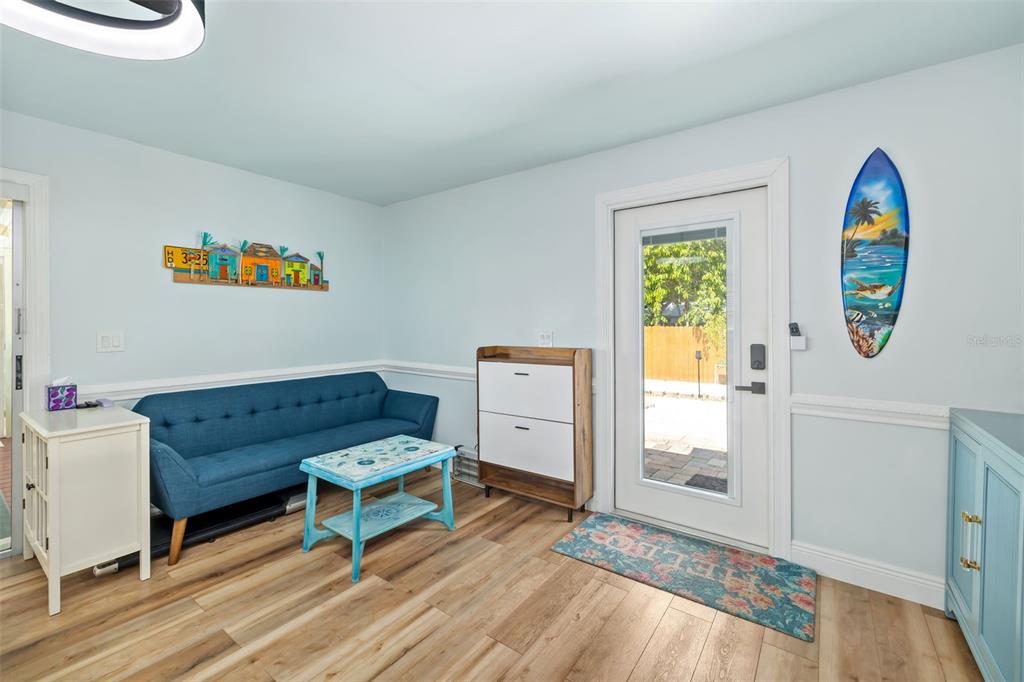 A light blue room features a blue sofa, a small coffee table, and a surfboard decoration — 2549 19TH STREET, SARASOTA, FL
