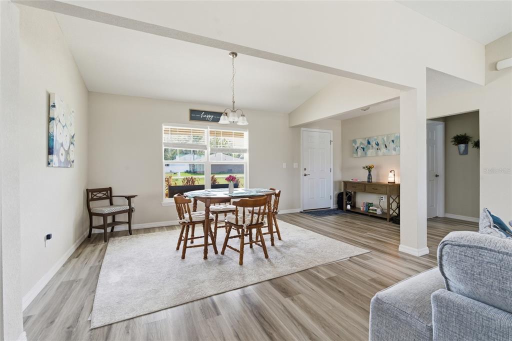 A dining area with a round table, wooden chairs, and light wood-look flooring — 13880 SW 45TH TERRACE, OCALA, FL