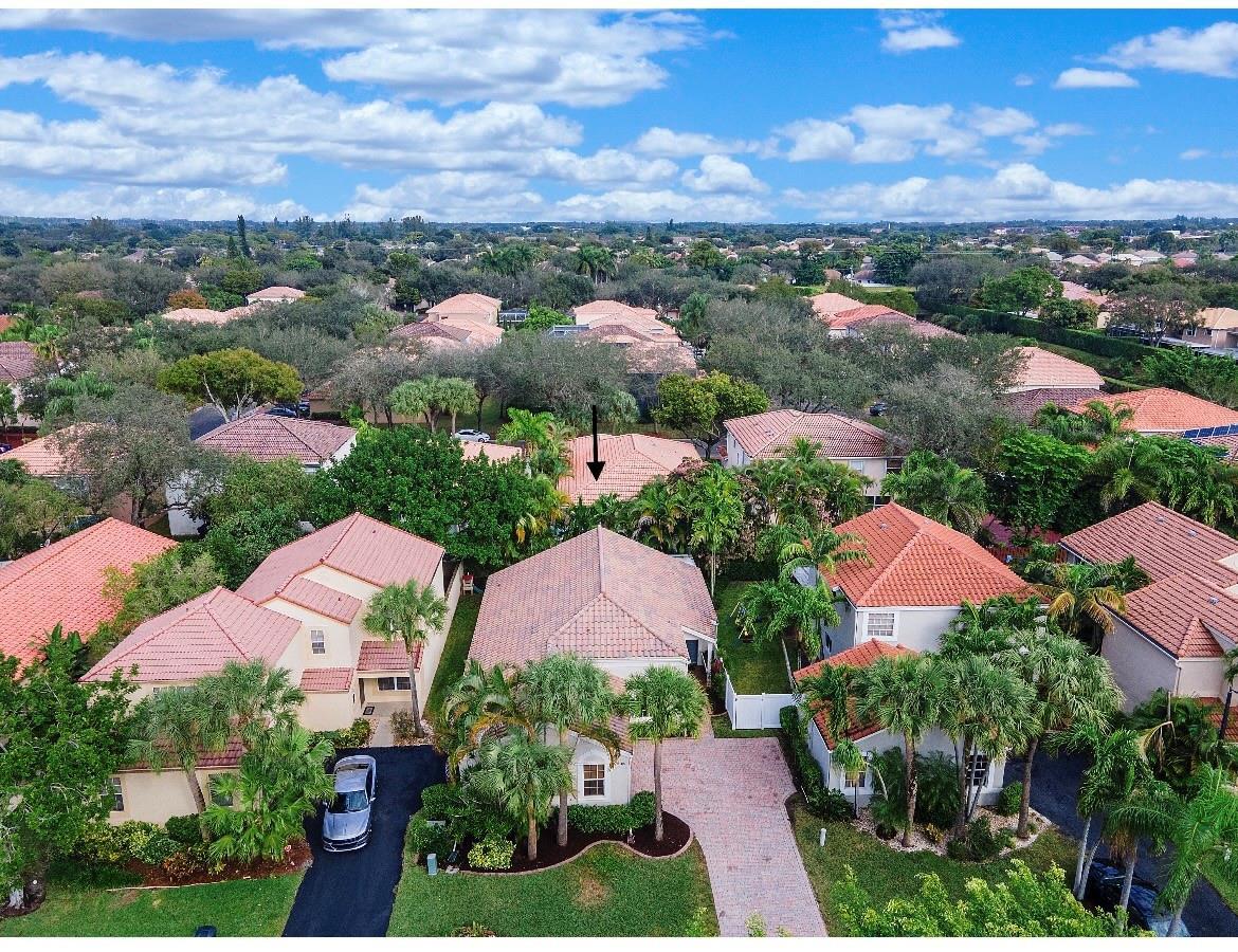 An aerial view shows several suburban houses with red tile roofs surrounded by lush trees — 6165 NW 77th Place, Parkland FL 33067, PARKLAND, FL