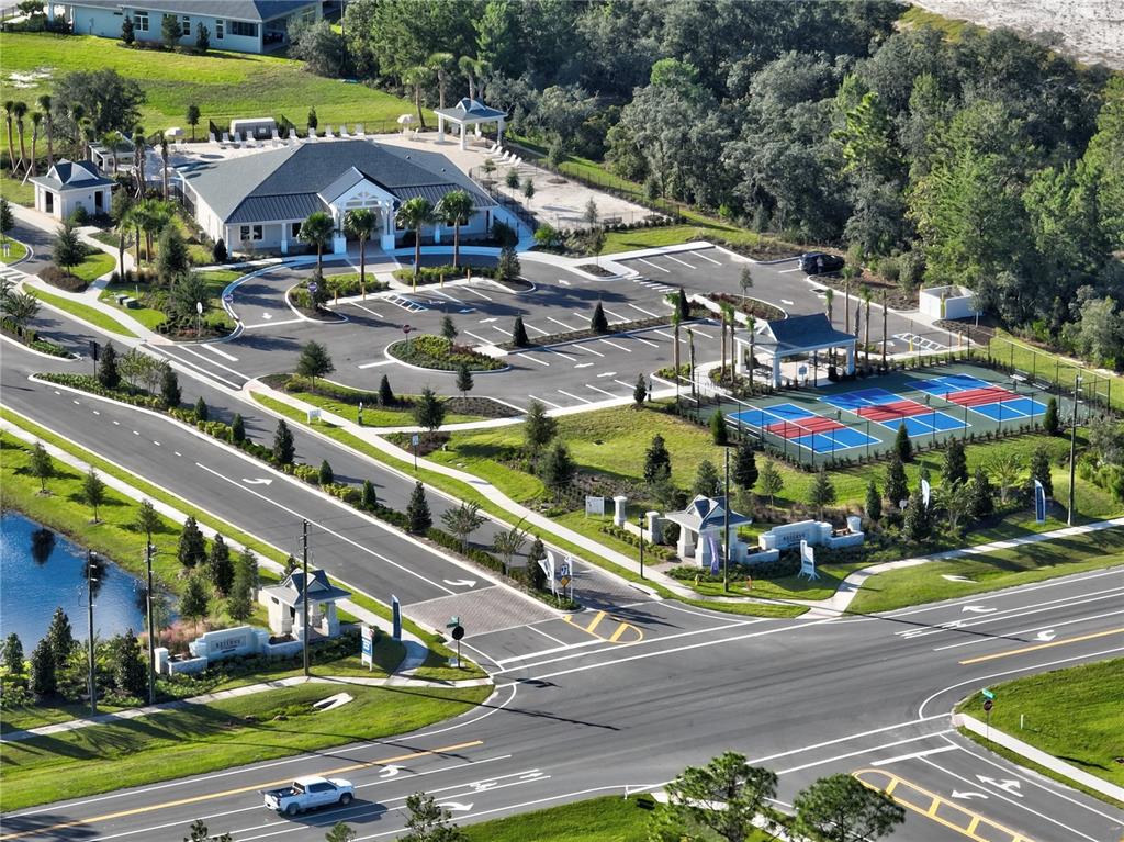 An aerial view shows a community clubhouse with a parking lot and tennis courts — 986 MEGANO BOULEVARD, DELAND, FL