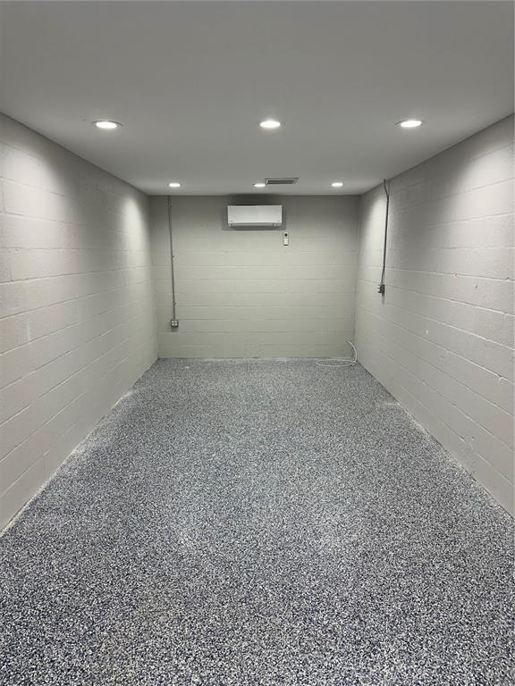 A finished basement room with gray painted block walls, recessed lighting, and speckled epoxy flooring — 110 SPIRIT LAKE ROAD UNIT 8, WINTER HAVEN, FL