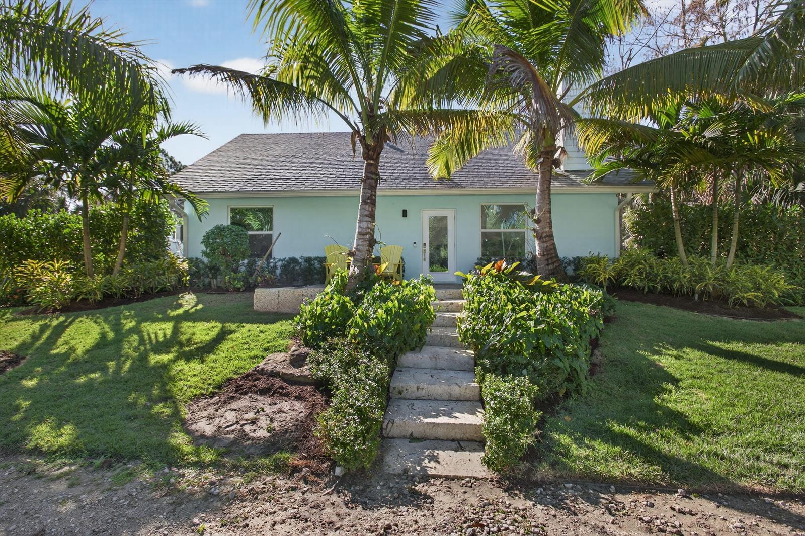 A light blue house with a stone staircase leading to the front door and palm trees — 9576 171st Street N, Jupiter FL 33478, JUPITER, FL