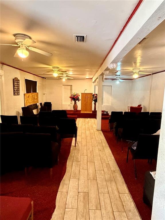 A small church sanctuary features rows of chairs, a wooden pulpit, and wood-look tile flooring — 1345 W KALEY AVENUE, ORLANDO, FL