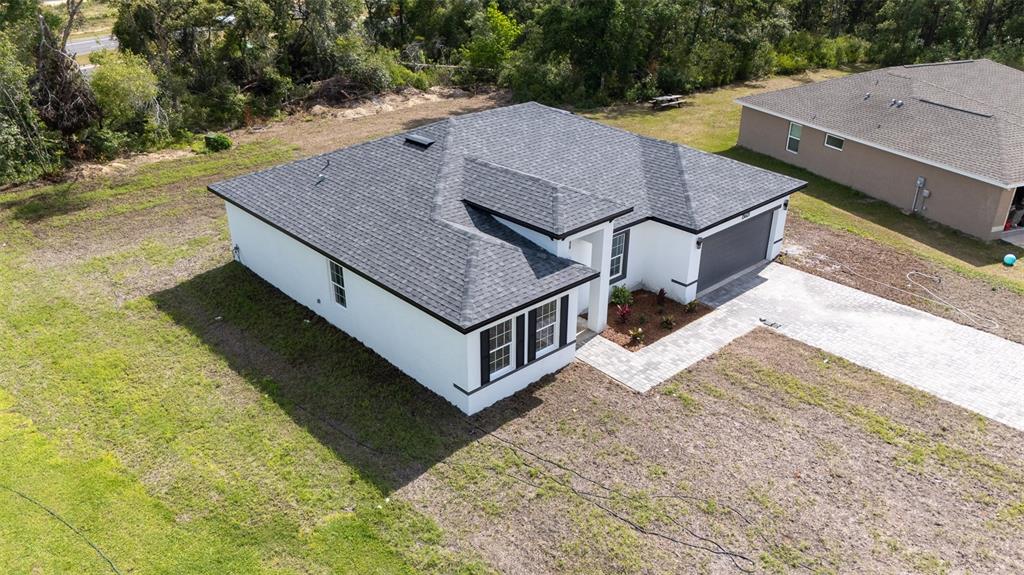 An aerial view of a single-story white house with a dark shingled roof and driveway — 13621 SW 40TH CIRCLE, OCALA, FL
