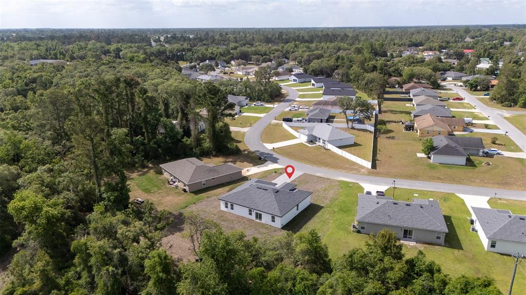 An aerial view shows a suburban neighborhood with single-family homes and surrounding wooded areas — 13621 SW 40TH CIRCLE, OCALA, FL