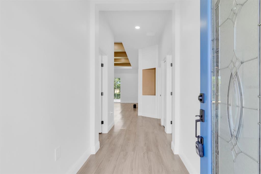 A bright entryway with light wood-look flooring leads into an open living space — 376 VILLA SORRENTO CIRCLE, HAINES CITY, FL