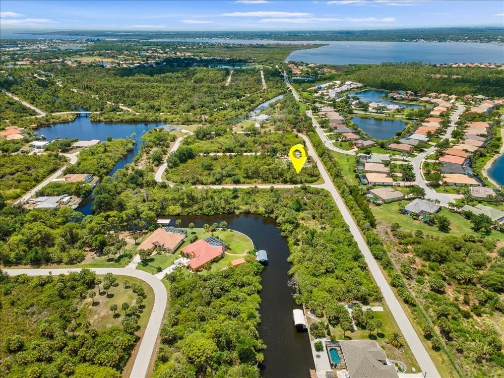An aerial view shows a vacant lot marked with a yellow pin near a canal — 2211 HALE STREET, PORT CHARLOTTE, FL
