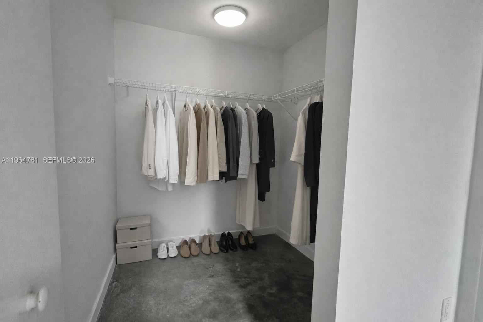 A walk-in closet features white walls, a wire shelving rack, and a concrete floor — 151 SE 1st St # 1501, Miami FL 33131, MIAMI, FL