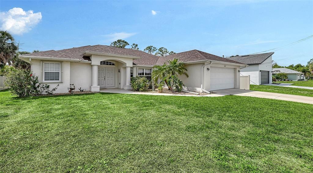 A single-story house with a beige stucco exterior, a brown roof, and a front lawn — 2051 SNOVER AVENUE, NORTH PORT, FL