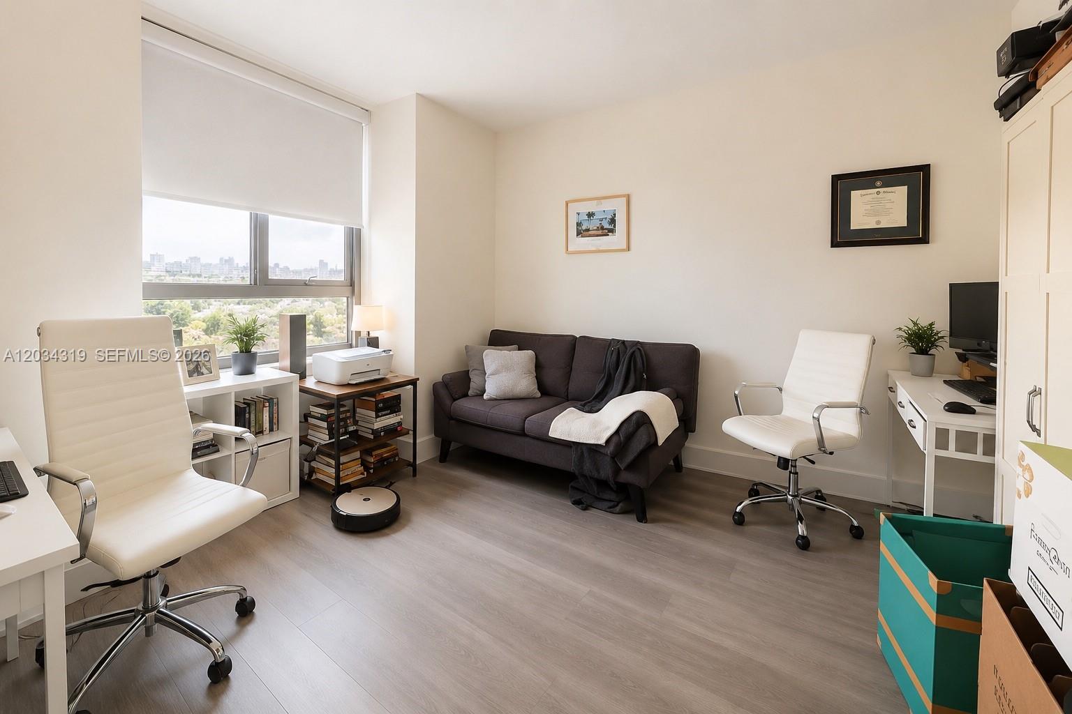 A home office features two white chairs, a dark sofa, and a window with city views — 90 SW 3rd St # 1413, Miami FL 33130, MIAMI, FL