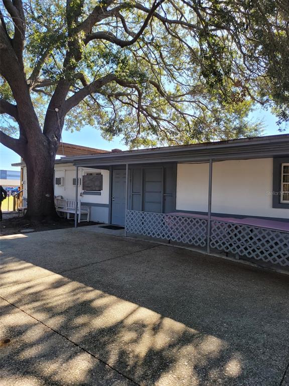 A concrete patio sits in front of a building with a covered porch and lattice — 5721 S TEXAS AVENUE, ORLANDO, FL