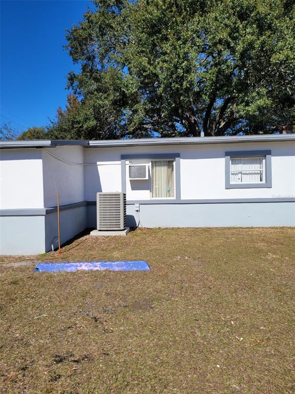 The exterior of a house features white walls, a gray base, and an air conditioning unit — 5721 S TEXAS AVENUE, ORLANDO, FL