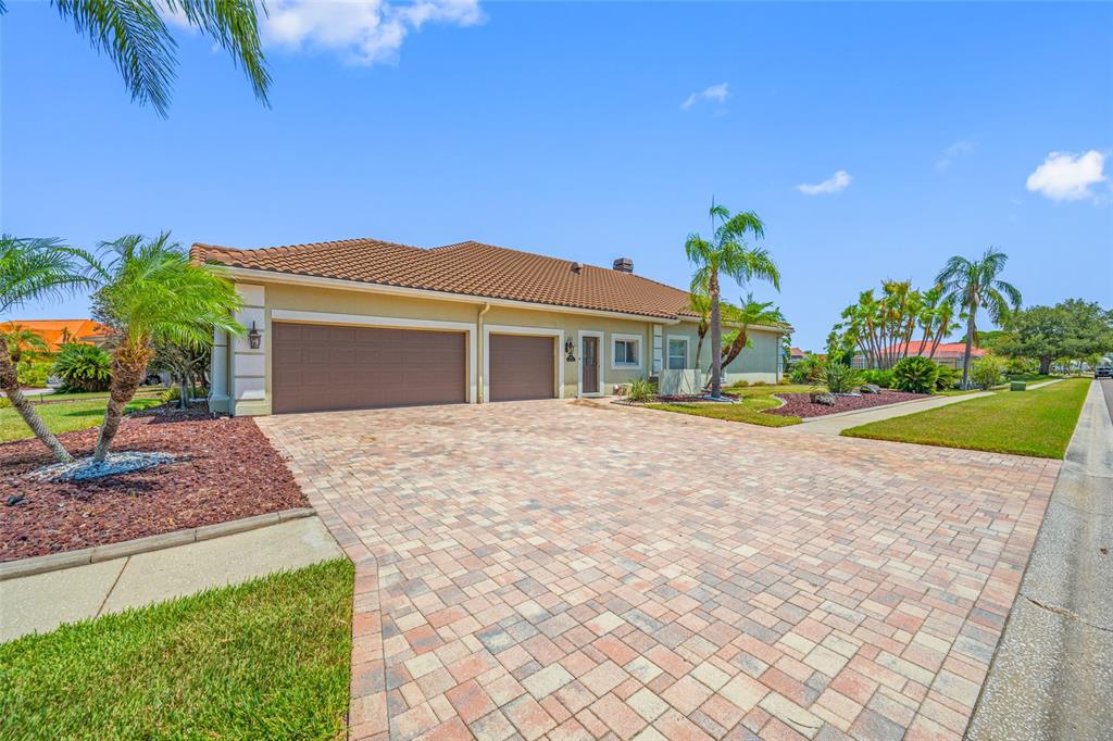 A tan house with a tile roof and a large paver driveway — 9801 COMPASS POINT WAY, TAMPA, FL