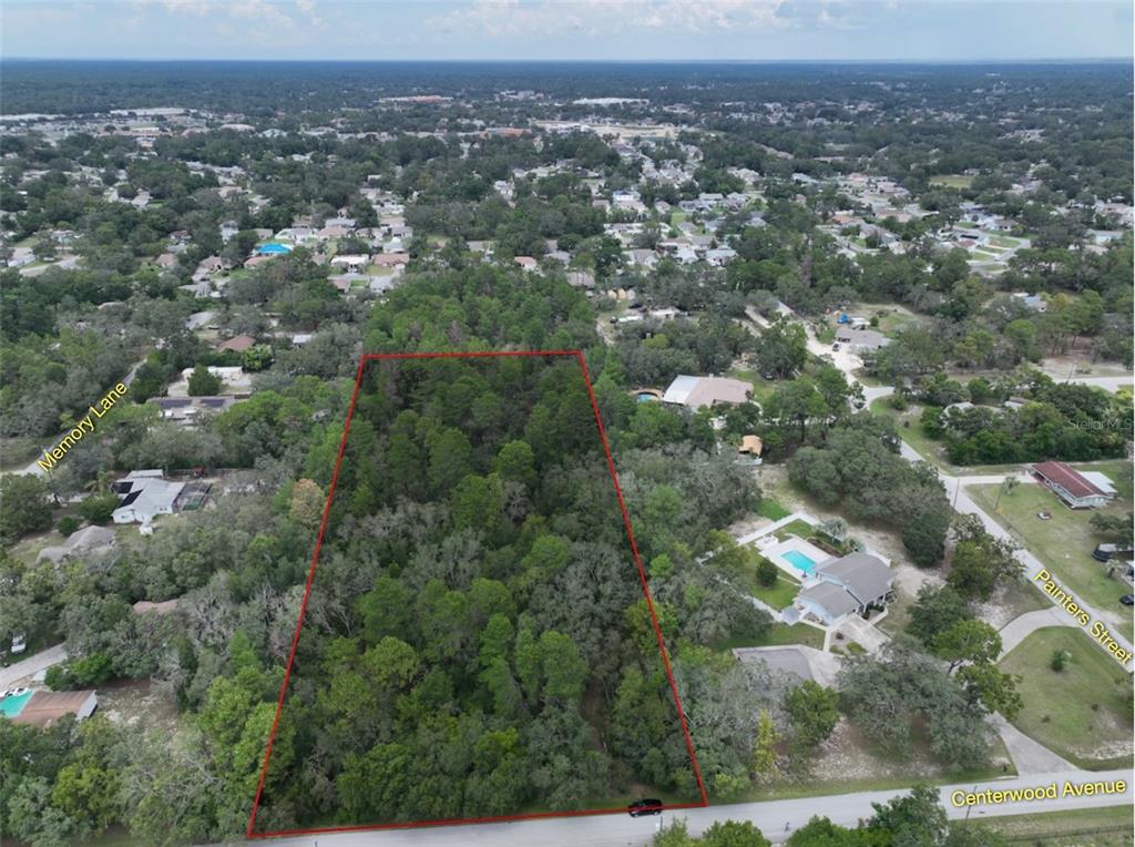 An aerial view shows a rectangular, wooded vacant lot outlined in red along a road — 0 CENTERWOOD AVENUE, SPRING HILL, FL
