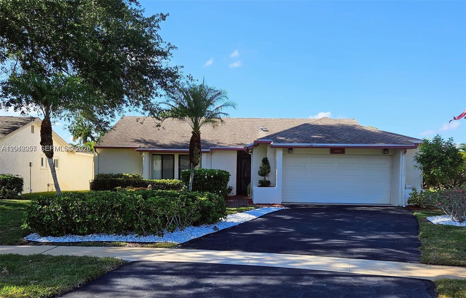 A single-story house with a white exterior, a two-car garage, and a landscaped front yard — 10301 Greenbriar Ct, Boca Raton FL 33498, BOCA RATON, FL