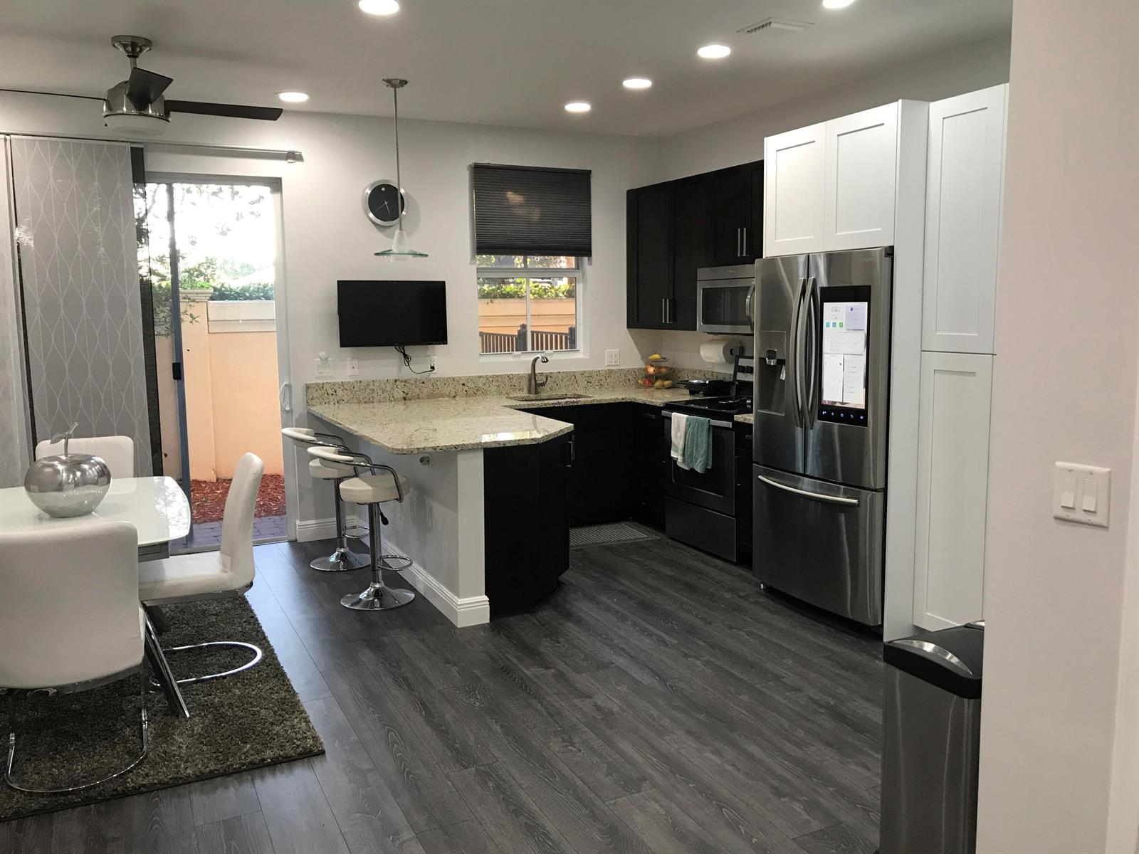 An entryway features a staircase with wood-look treads, gray flooring, and a metal shoe rack — 6960 Long Pine Circle, Coconut Creek FL 33073, COCONUT CREEK, FL