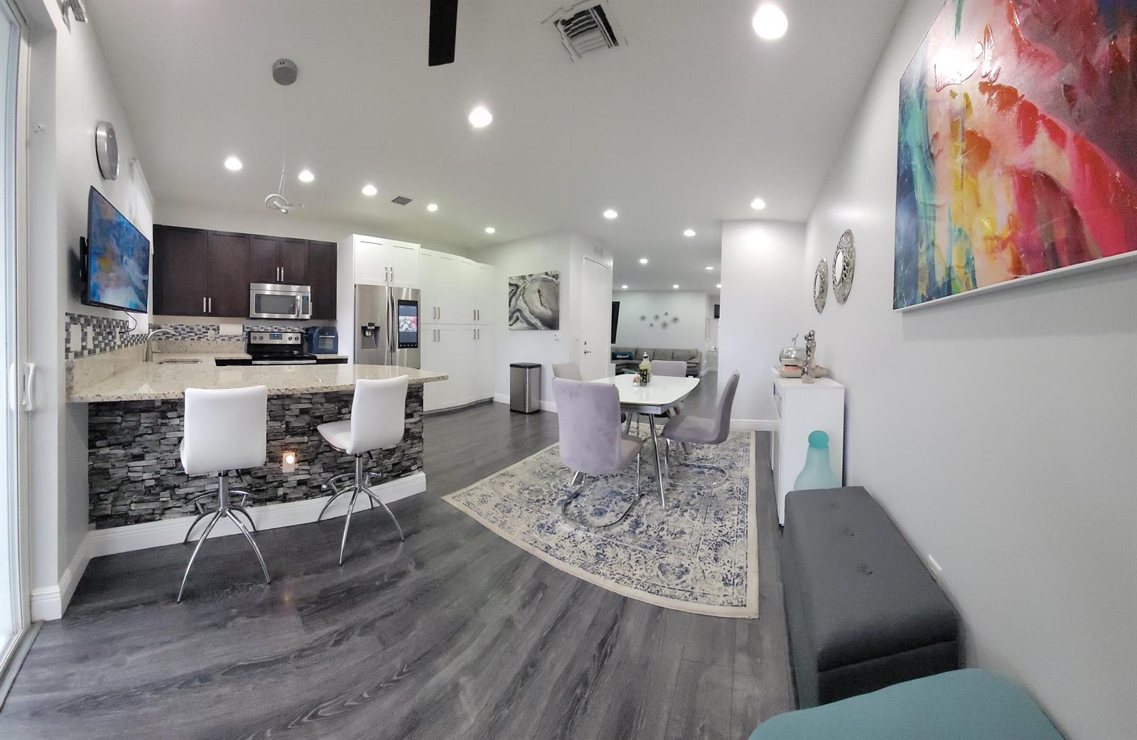 A living room features a grey sectional sofa, a blue area rug, and a glass table — 6960 Long Pine Circle, Coconut Creek FL 33073, COCONUT CREEK, FL