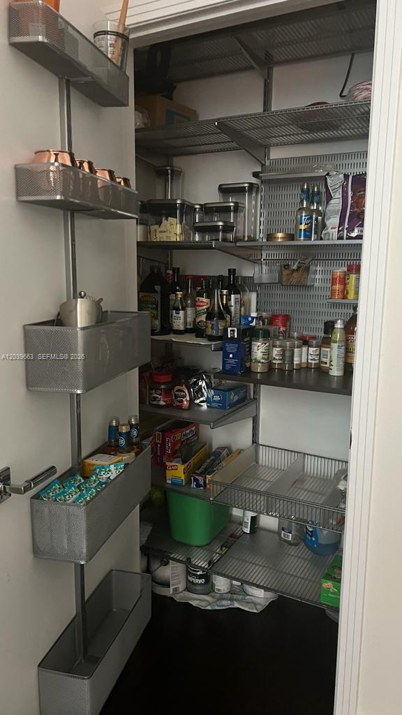 A pantry features wire shelving units, a door-mounted storage rack, and various food containers — 9066 SW 73rd Ct # 607, Miami FL 33156, MIAMI, FL