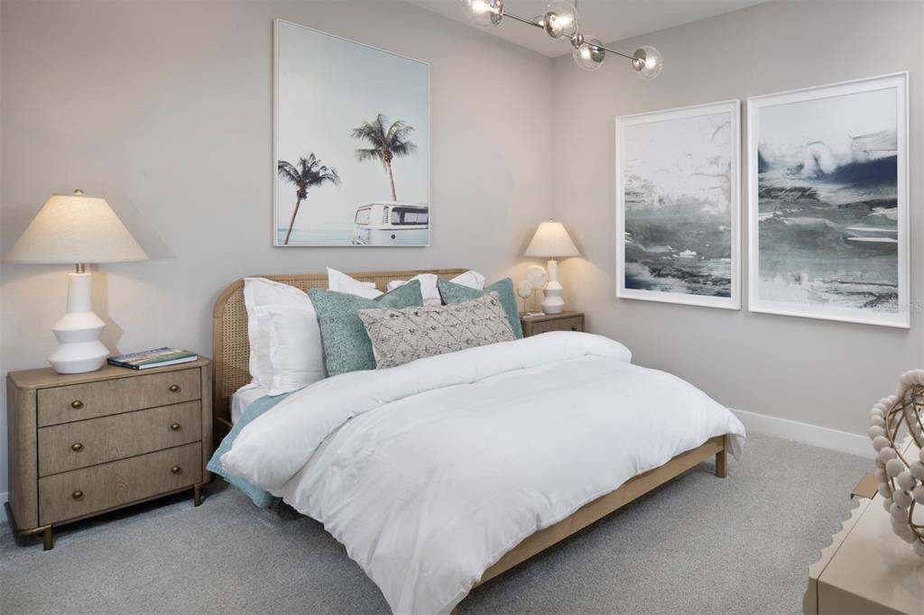 A bedroom features a rattan bed, two nightstands with lamps, and three framed wall art pieces — 11740 BOUNDLESS TERRACE, VENICE, FL