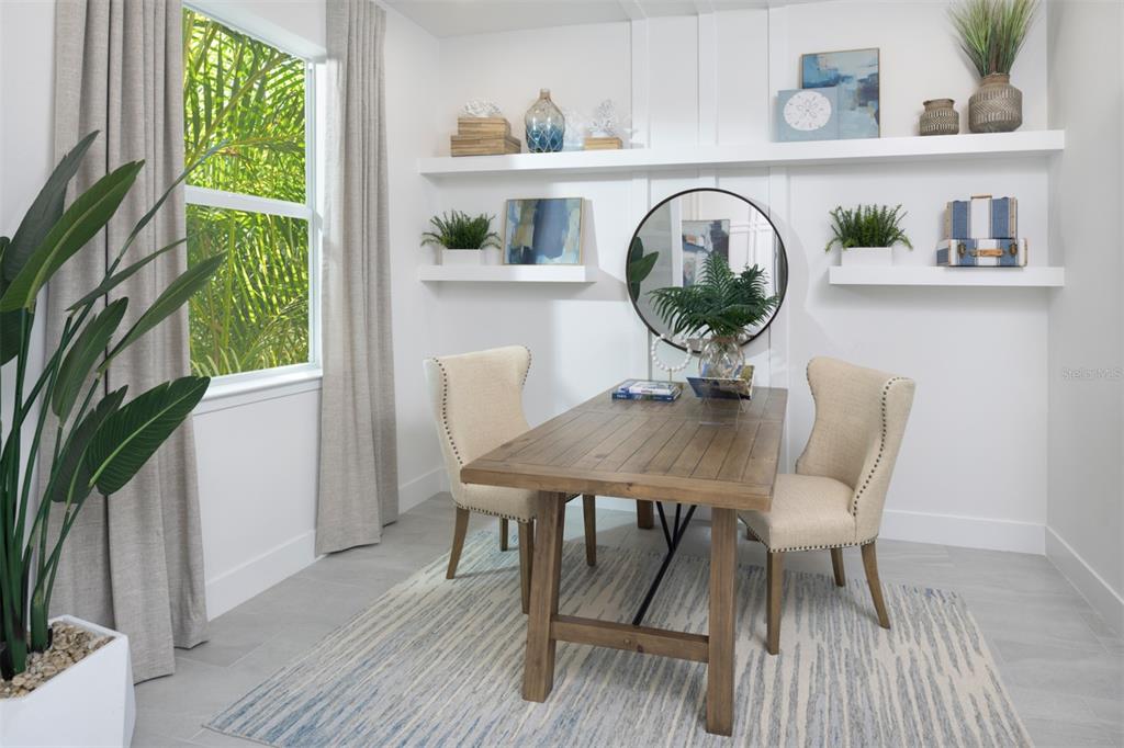 A home office features a wooden desk, two upholstered chairs, and white floating wall shelves — 11740 BOUNDLESS TERRACE, VENICE, FL