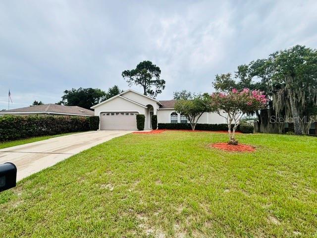 A single-story house with a two-car garage, a concrete driveway, and a front lawn — 2830 ASCOT LANE, DELTONA, FL