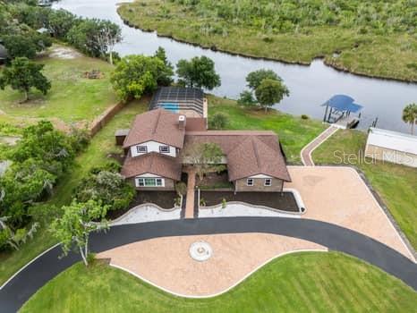 An aerial view shows a house with a brown roof, pool, and dock by water — 2309 CYPRESS WALK WAY, RUSKIN, FL