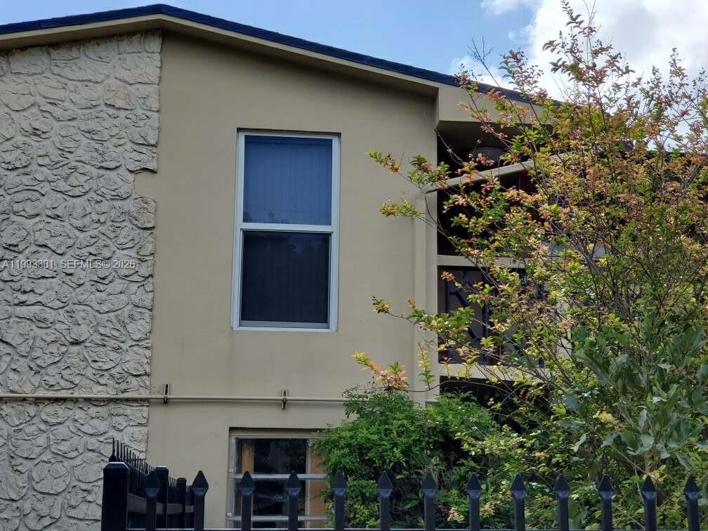 The exterior of a two-story building features a stone facade, stucco walls, and a window — 3901 SW 78th Ct # 221, Miami FL 33155, MIAMI, FL