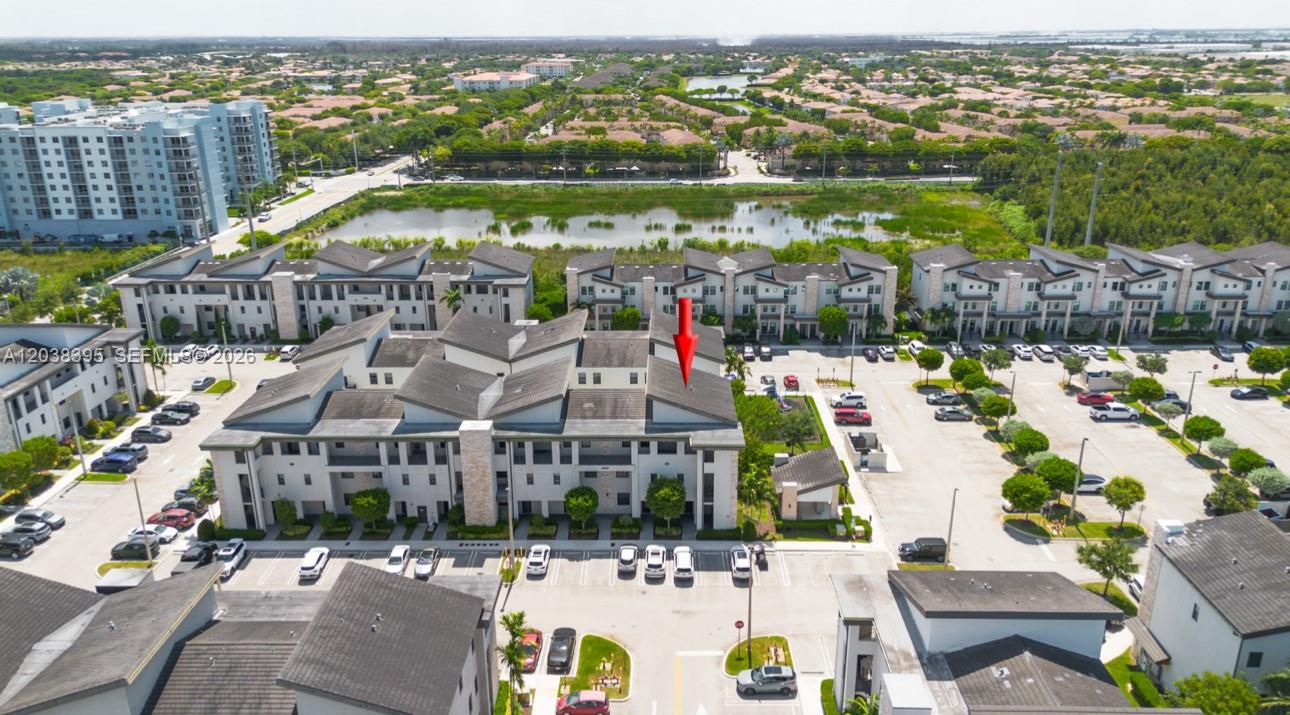 An aerial view shows a multi-story residential building with a red arrow pointing to the roof — 10443 NW 82nd St # 8, Doral FL 33178, DORAL, FL