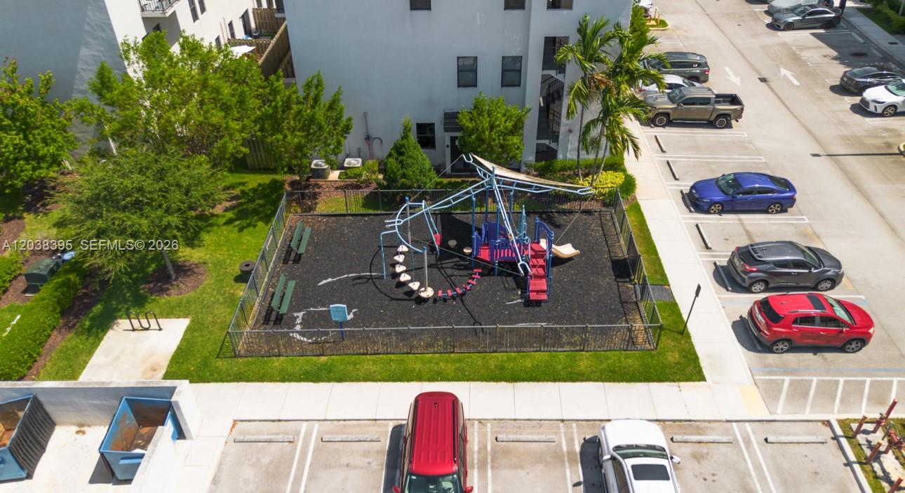 An aerial view shows a fenced playground with play equipment next to a parking lot — 10443 NW 82nd St # 8, Doral FL 33178, DORAL, FL