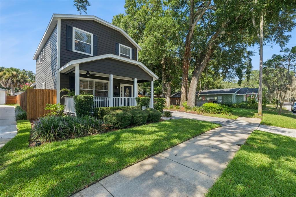 A two-story dark gray house with a front porch and a sidewalk in the foreground — 1810 ILLINOIS STREET, ORLANDO, FL