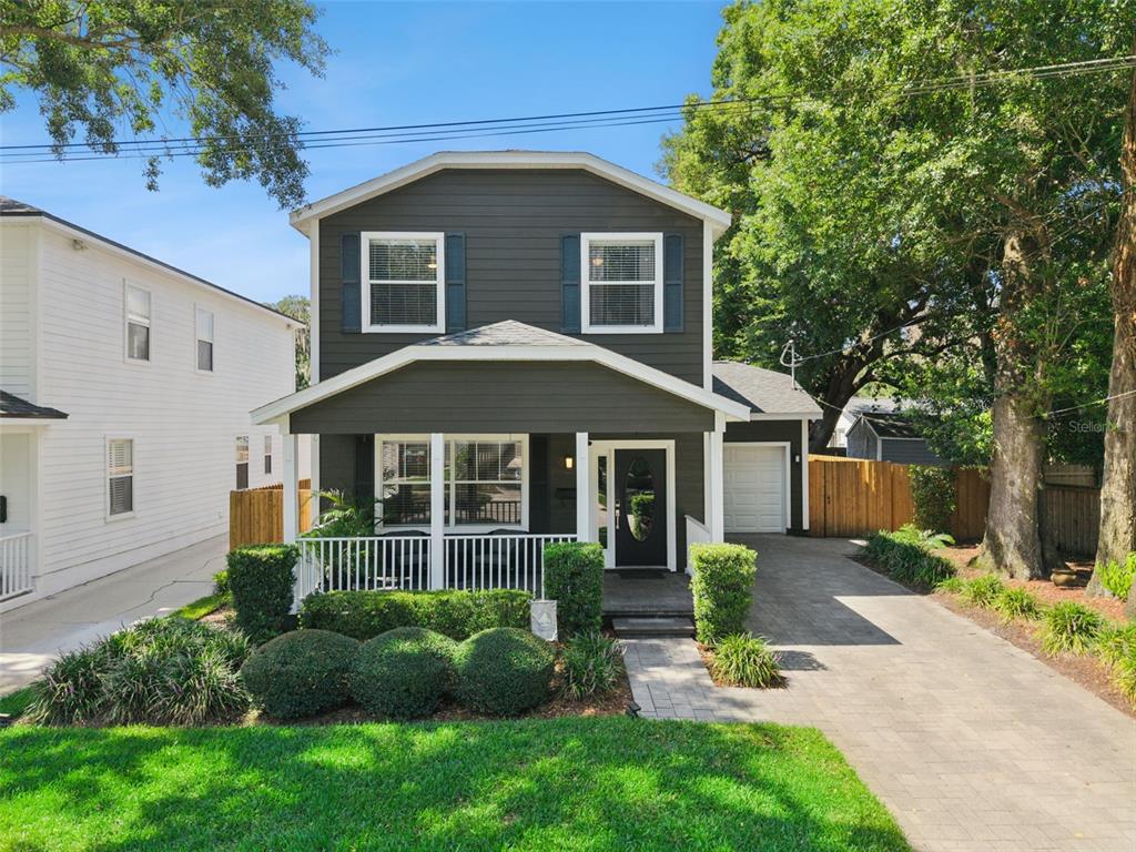 A two-story dark gray house features a front porch, white trim, and a paved driveway — 1810 ILLINOIS STREET, ORLANDO, FL