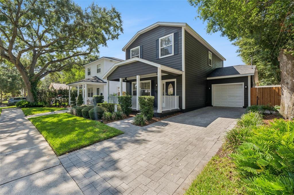 A dark gray two-story house with a white porch, garage, and paved driveway — 1810 ILLINOIS STREET, ORLANDO, FL