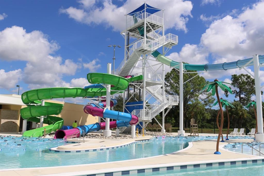 A tall water slide tower stands next to a swimming pool under a blue sky — ABDELLA LANE, NORTH PORT, FL