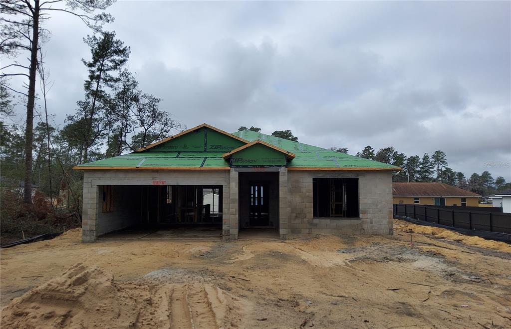 A single-story house under construction with concrete block walls and a green roof sheathing system — 5238 SW 164TH STREET ROAD, OCALA, FL