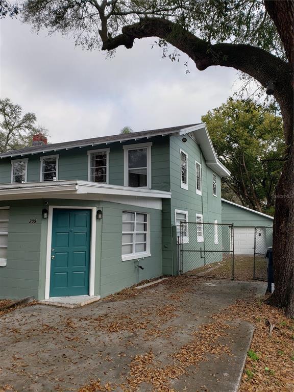 A two-story green house with a teal front door and a detached garage — 209 W KIRBY STREET, TAMPA, FL