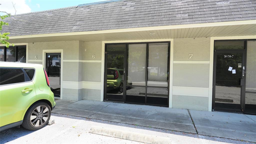 A row of commercial office units with glass doors and a lime green car parked outside — 5650 PARK BOULEVARD N UNIT 6, PINELLAS PARK, FL