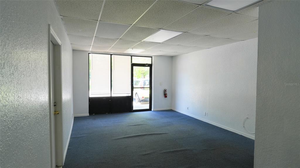 An empty office space features blue carpeting, white walls, and a drop ceiling — 5650 PARK BOULEVARD N UNIT 6, PINELLAS PARK, FL