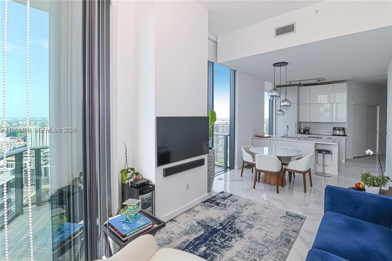 A modern open-concept living and dining area features white marble floors, floor-to-ceiling windows, and city views — 501 NE 31st St # 4008, Miami FL 33137, MIAMI, FL